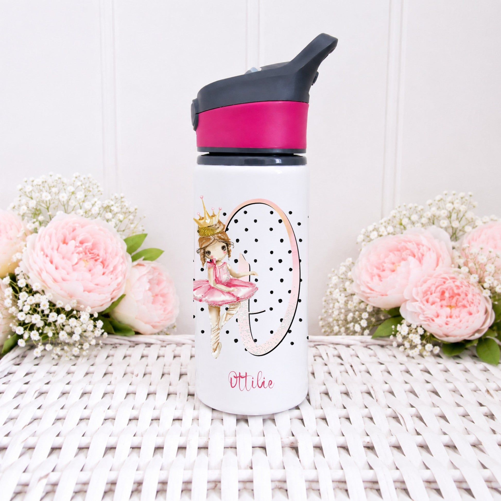 Personalized water bottle with floral design and pink cap on a white surface with flowers.
