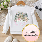 White sweatshirt with a Christmas design on a wooden surface, with text indicating '3 styles available'.