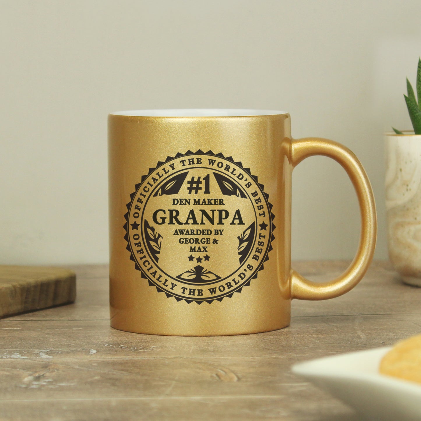 Gold mug with engraved text on a wooden surface
