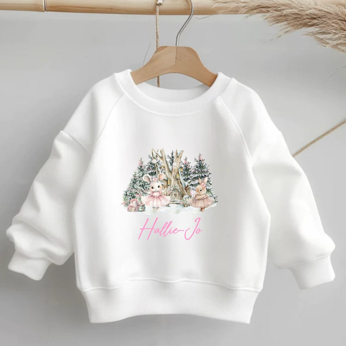 White sweatshirt with a Christmas-themed design and 'Hallie Jo' branding on a gray background.
