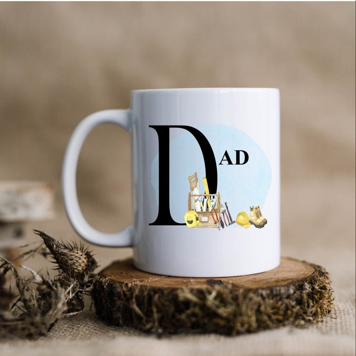 White mug with 'DAD' and illustrations on a wooden coaster with a natural background