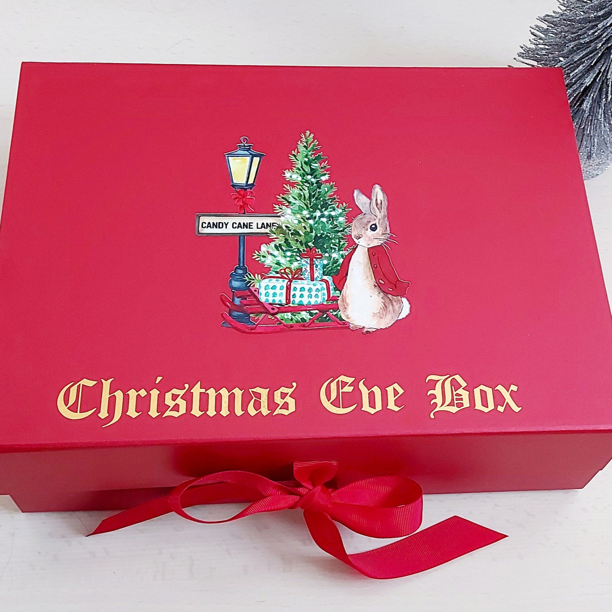 Red Christmas Eve box with festive design and bow on a white background