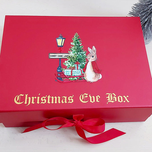 Red Christmas Eve box with festive design and bow on a white background