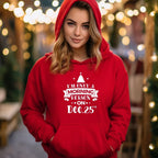 Person wearing a red hoodie with a Christmas-themed message in a festive setting.