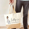 Tote bag with 'Lilly's Honeymoon' design held by a person wearing gray pants.