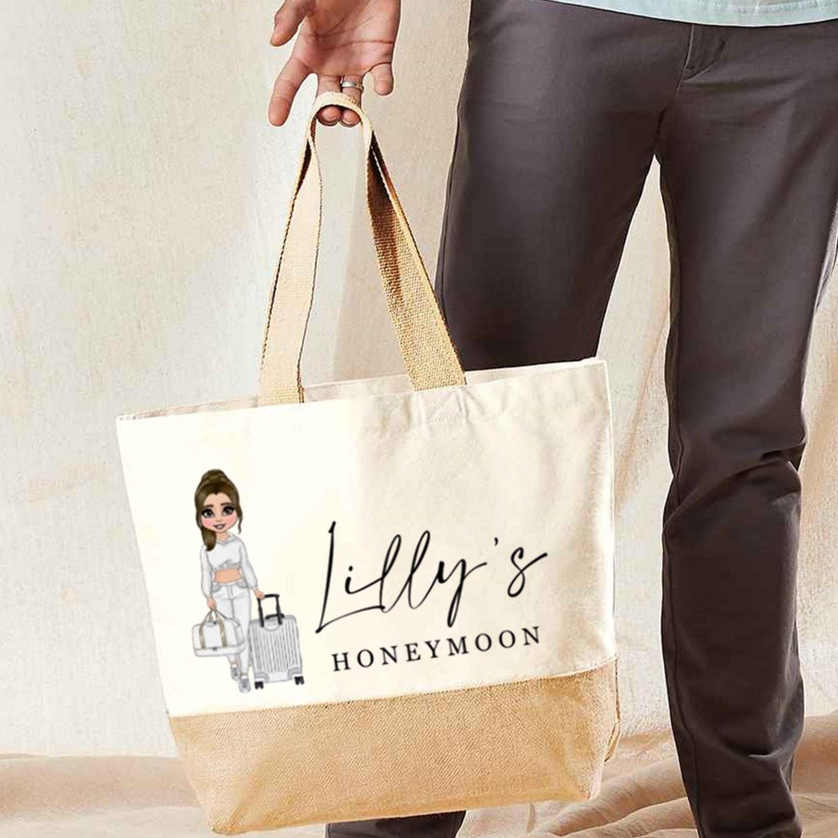 Tote bag with 'Lilly's Honeymoon' design held by a person wearing gray pants.