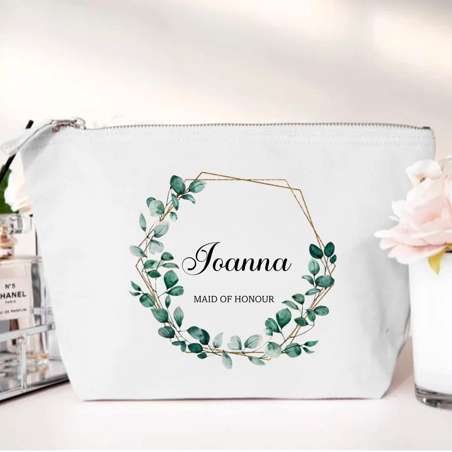 White pouch with green leaf design and 'Joanna Maid of Honour' text on a white background