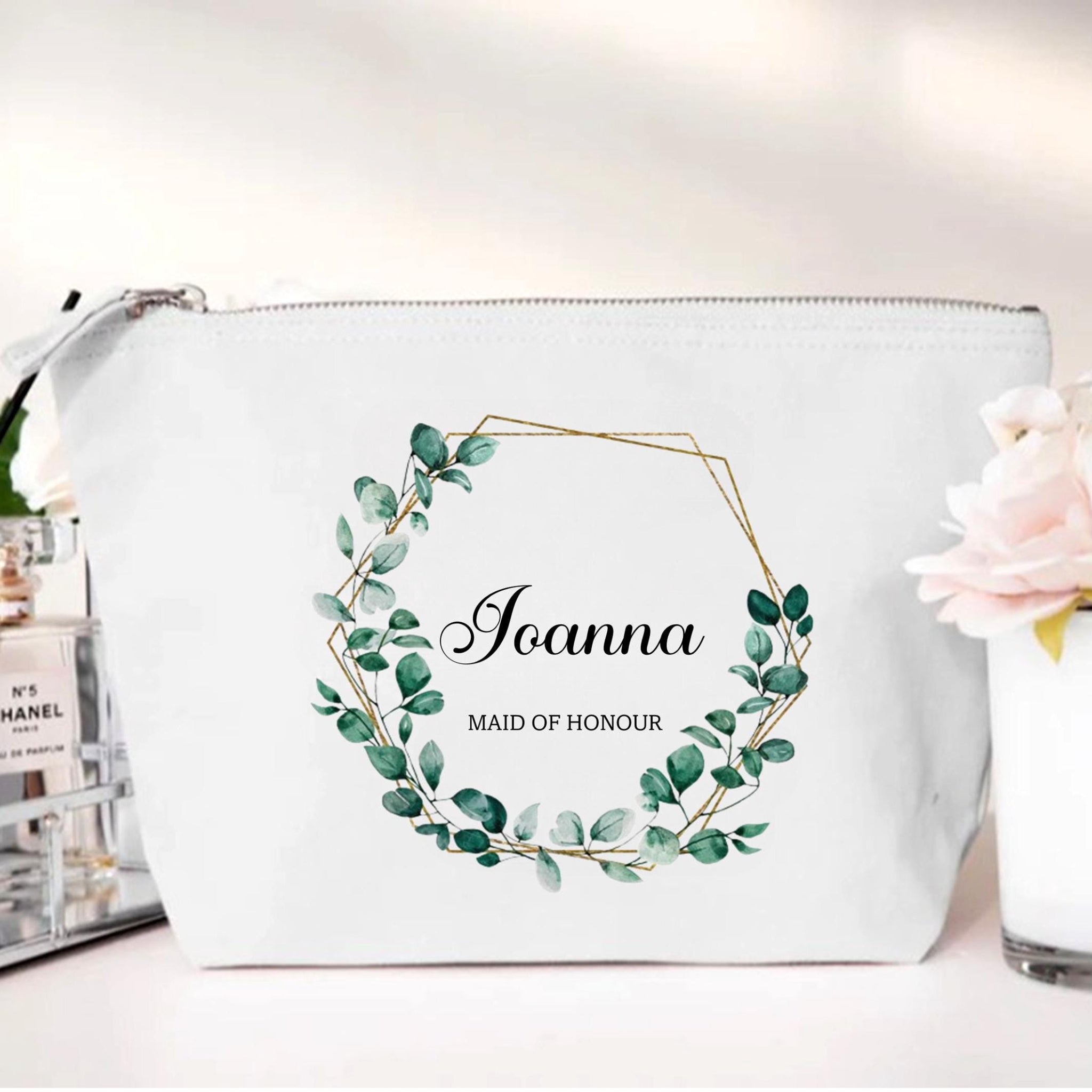 White pouch with green leaf design and 'Joanna Maid of Honour' text on a white background