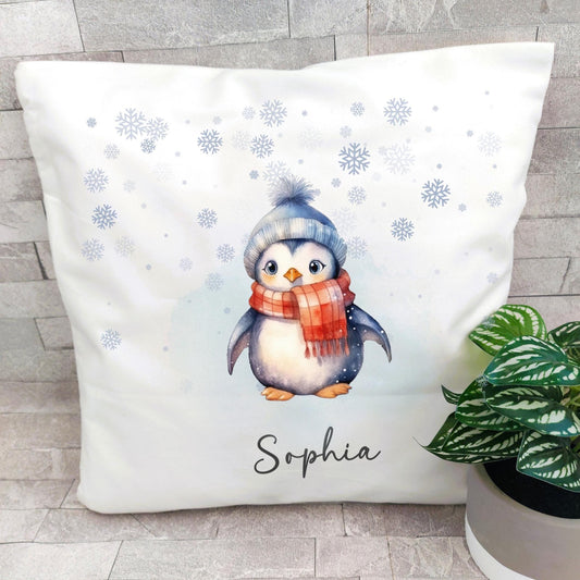Decorative pillow with a penguin design and the name 'Sophia' on a light gray floor.