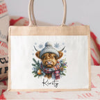 Tote bag with a highland cow illustration wearing a hat and scarf.