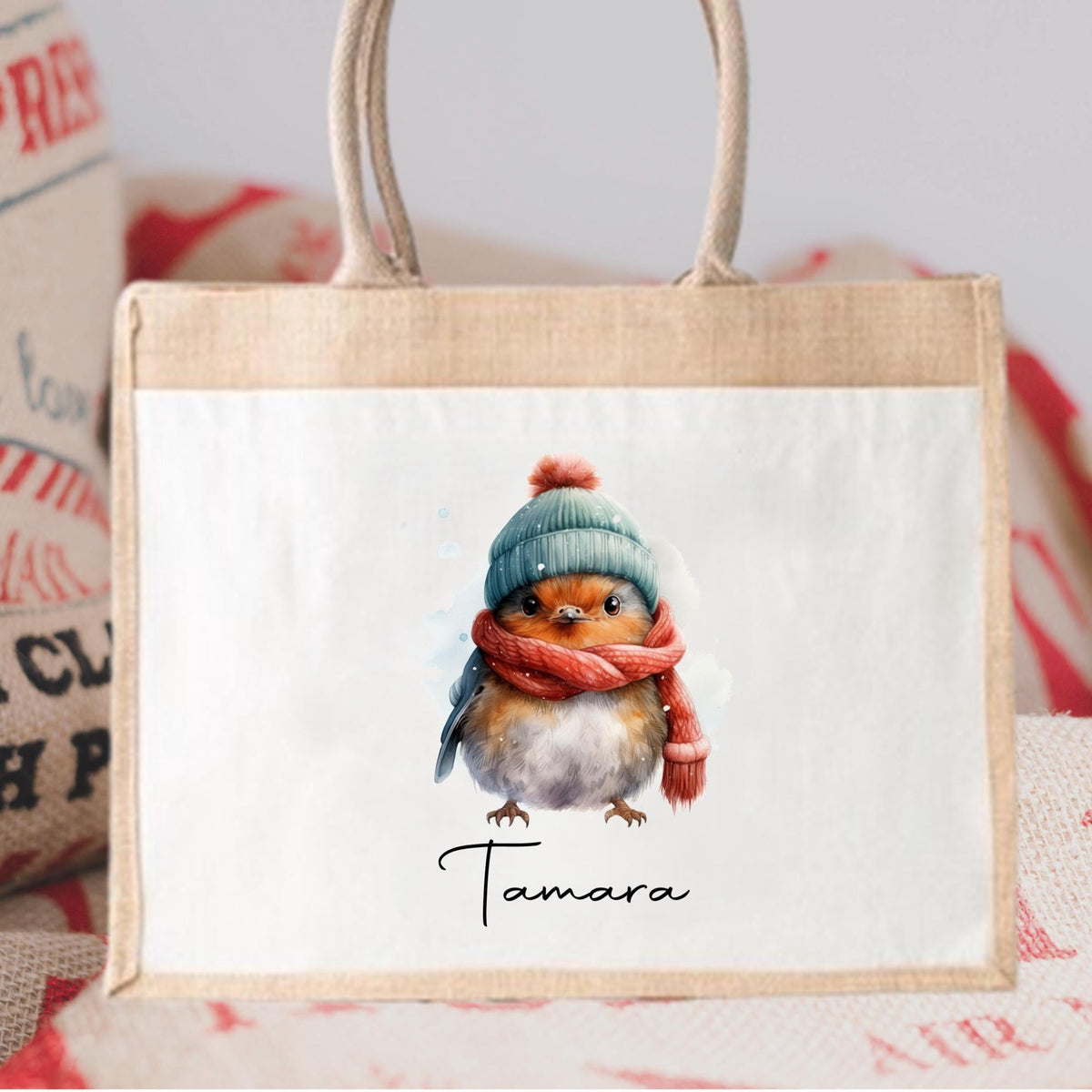 Small bag with a cute illustration of a bird wearing a hat and scarf, branded 'Tamara', on a textured background.